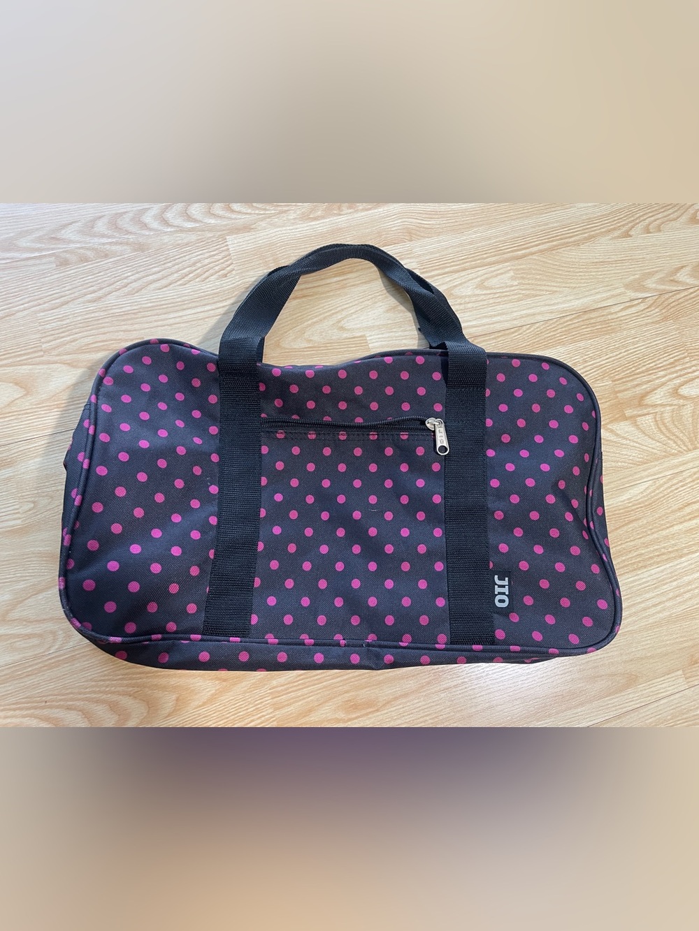Vintage black travel duffel bag with a pink polka dot pattern
